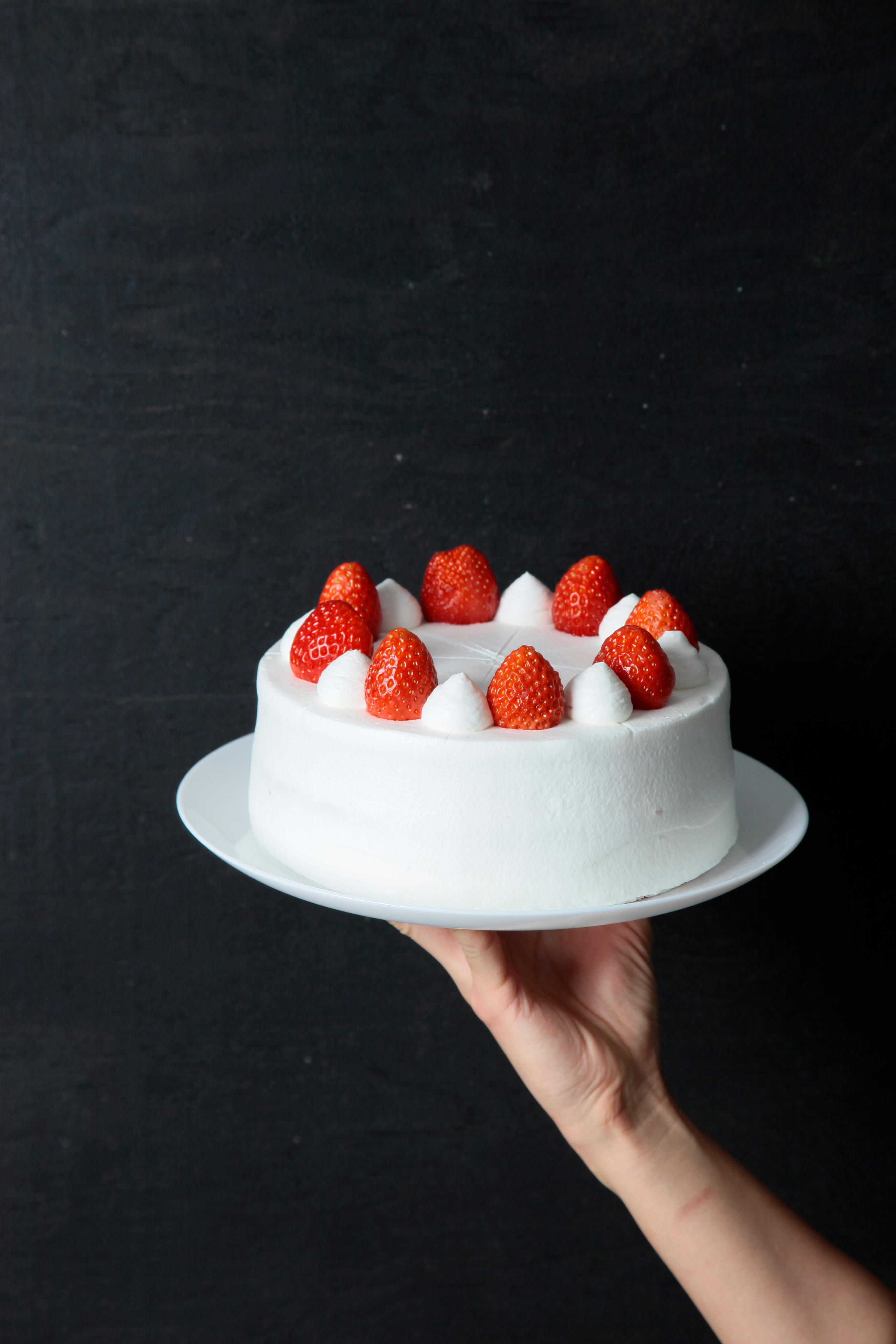 A strawberry TurtleHip cake held by hand
